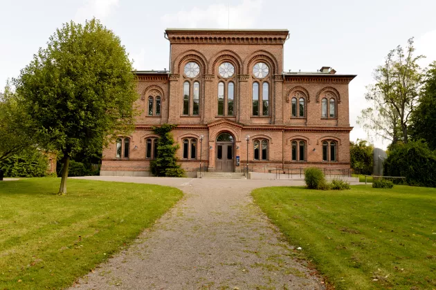 A photograph of the Pufendorf building in Lund. Green lawns surround it. 